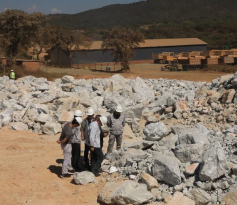 Workers inspecting Lithium ore stockpile
