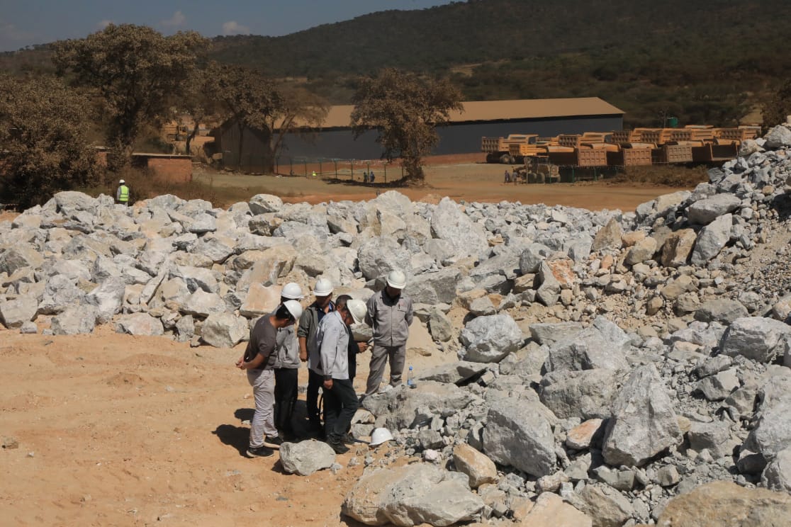 Workers inspecting Lithium ore stockpile